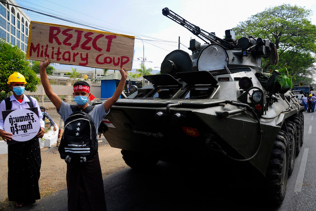 Protesters pose for photos near an armored personnel carrier parked outside the Central Bank of Myanmar as they gather to protest against the military coup, in Yangon, Myanmar on February 15, 2021. Photo by Stringer via Anadolu Images