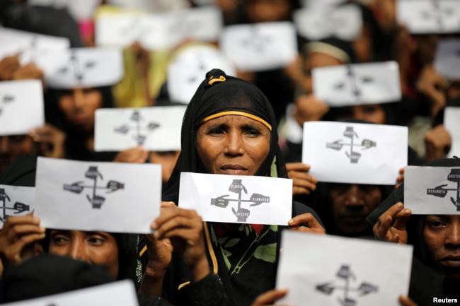 Rohingya refugee women hold placards as they take part in a protest at the Kutupalong refugee camp to mark the one-year anniversary of their exodus from Myanmar, in Cox's Bazar, Bangladesh, Aug. 25, 2018.